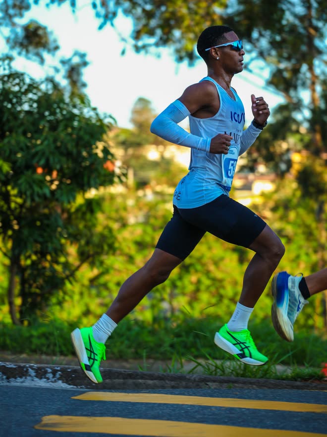 Kauê de Souza de perfil, em passada aberta durante a 41ª Corrida Integração, de regata ICASA e manguitos brancos