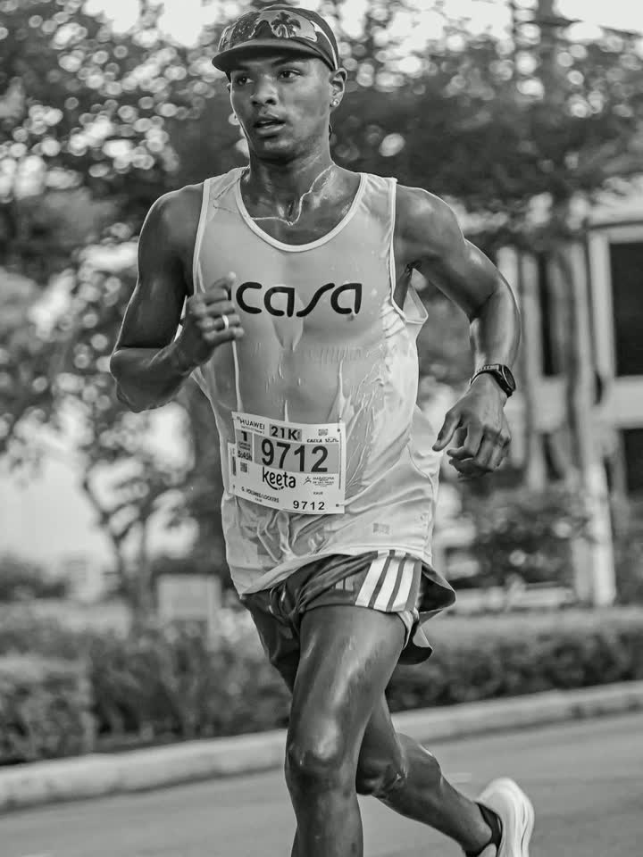 Kauê de Souza correndo os 21 km com a regata encharcada, número de peito 9712
